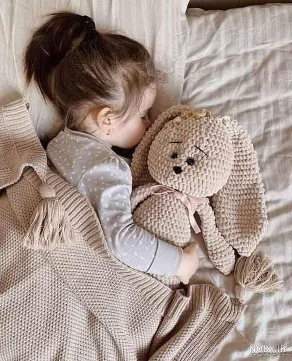 دختر زیبای شش ساله ای که با خرس عروسکی خود روی تخت خوابیده است 1099605