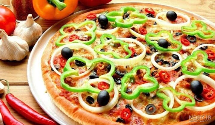 عکس پیتزا با یک برگ ریحان روی آن در پس زمینه چوبی – عکس با کیفیت و ...