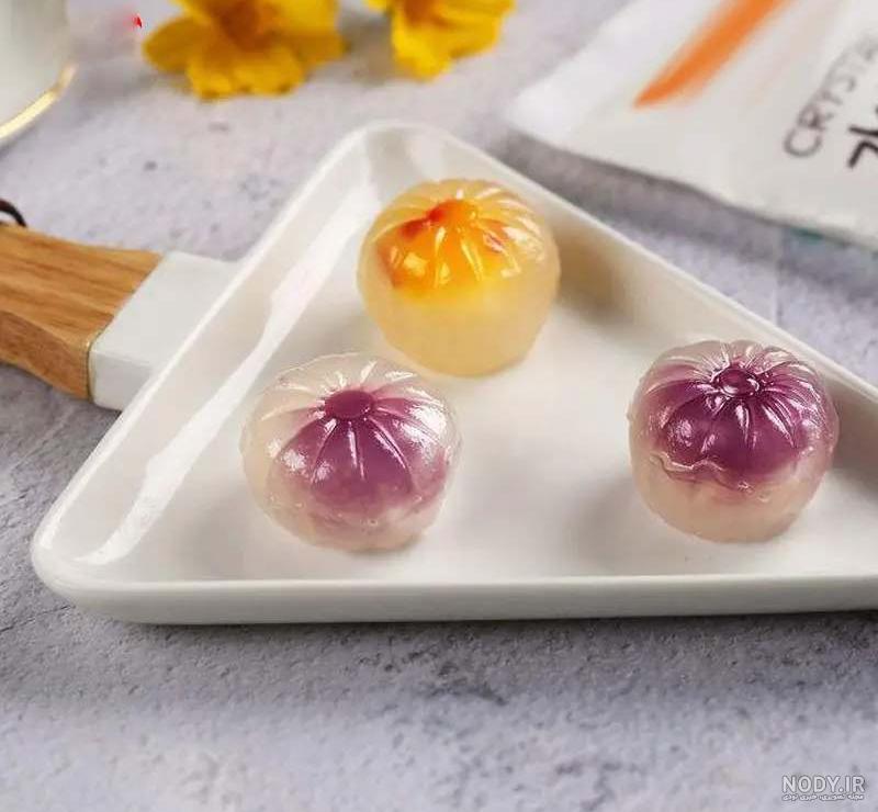 عکس شیرینی ژله چند رنگ در دست خانمی با رنگ ناخن روشن – عکس با کیفیت و ...