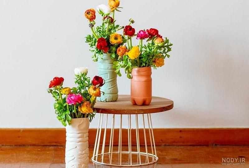 عکس گلدان شیشه ای پر از شاخه گلهای زیبای طبیعی