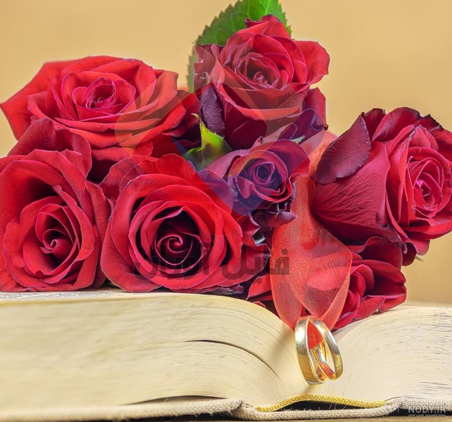 کتاب با گل رز در بالای زمینه ابریشمی 1223314