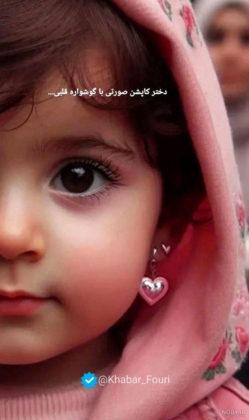 عکس دختر کاپشن صورتی با گوشواره های قلبی